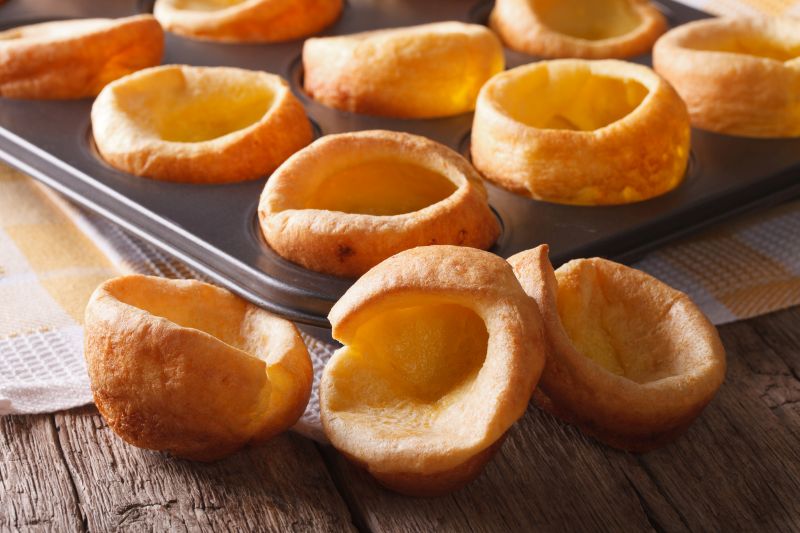 Yorkshire Puddings mit Backform im Hintergrund