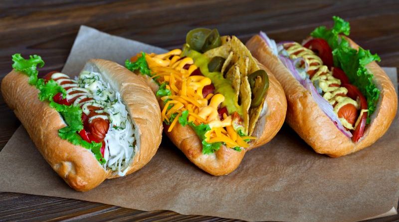 Drei verschiedene Hot Dogs auf Holztisch